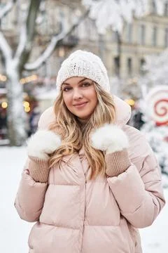 Young woman in warm light clothes on the background of a snowy tree on a city Stock Photos
