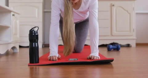 Young woman watching video tutorial on phone while working out with exercise Stock Footage 128545525