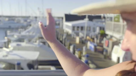 Young Woman Waves Goodbye Or Hello, From Moving Boat, To A Marina Stock Footage 59738021