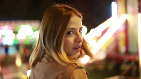 Young woman waving and beckoning to camera in amusement park Stock Footage 59556311