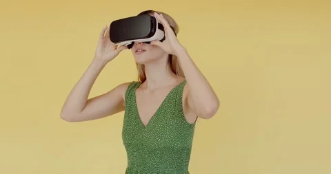 Young woman wearing using virtual reality VR glasses helmet headset Stock Footage 207088587