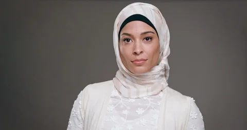 Young woman wearing a white hijab looking into camera with a powerful expression Stock Footage 127068863