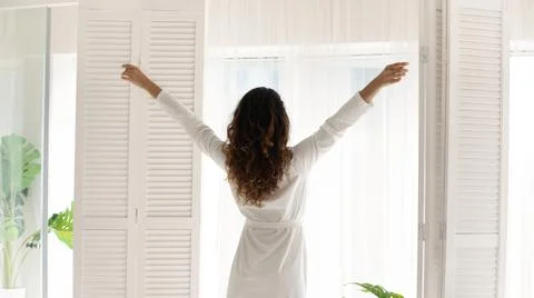 Young woman welcoming new day at home. Stock Photos
