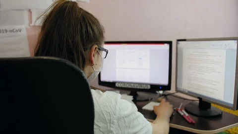 Young woman work for the computer in protective mask against a coronovirus Stock Footage 127504472