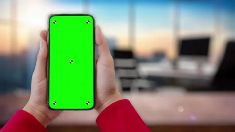 Young woman in work office using smartphone with green mock up screen chroma key Stock Footage 306171953