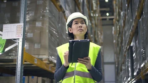 Young woman worker is using tablet during working process in modern warehouse. Stock Footage 127674333
