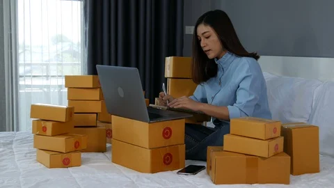 Young woman working and using laptop computer to selling product online on a bed Stock Footage 130096818