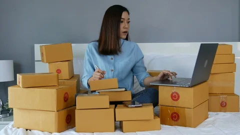 Young woman working and using laptop computer to selling product online on a bed Stock Footage 130103539
