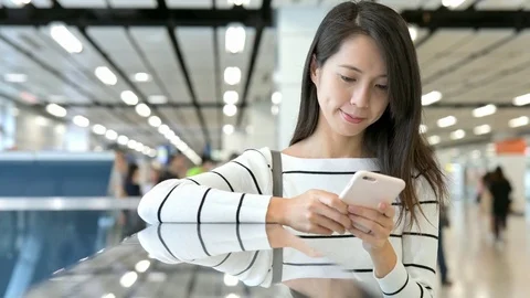 Young Woman working on cellphone in station hall Stock Footage