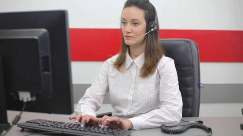 Young woman working on computer and talking on the telephone in call center Stock Footage 74101969