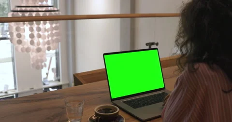 Young woman is working on a computer with a mock-up green screen. Digital nomad  Video stock 156778728