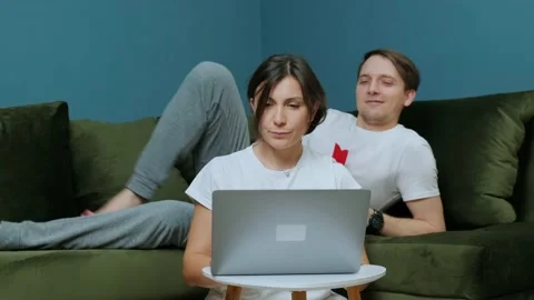 Young woman that is working at the computer receiving a gift from her husband. Stock Footage 147346514