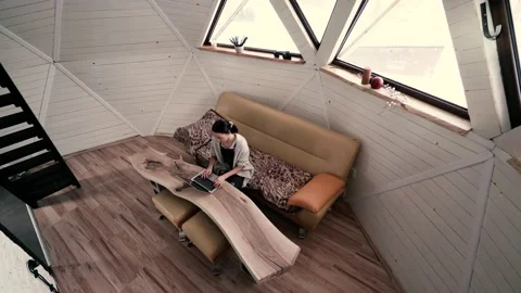 Young Woman Working on the Computer, Sitting in the Modern Tiny House Alone Stock Footage 146838539