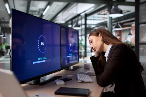 Young Woman Working On Computer Update To Improve Slow Desktop Speed. Stock Photos
