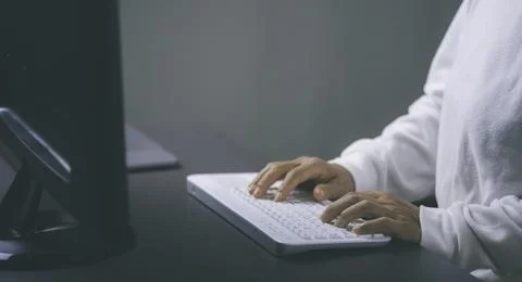 A young woman working in front of a computer lying on the desk , Stock Photos