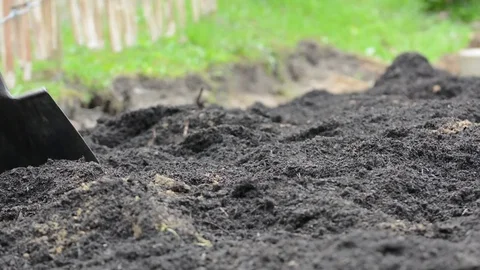 Young woman working in garden digging dirt and soil Stock Footage