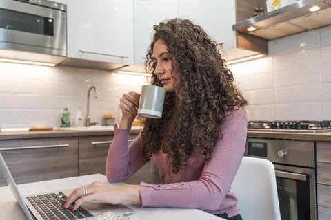 Young woman is working at home on the computer during the restrictions due to Stock Photos