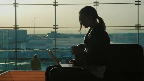 Young woman working with laptop in airport terminal. Waiting for my flight Stock Footage
