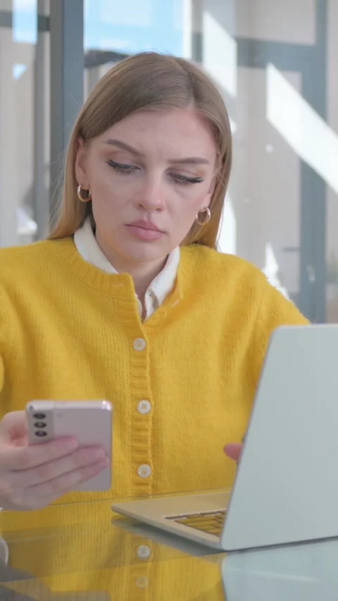 Young Woman Working on Multiple Digital Devices at Work, vertical video Stock Footage 324695222