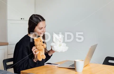Young woman working as online nanny from home. Online education for children at Stock Photos