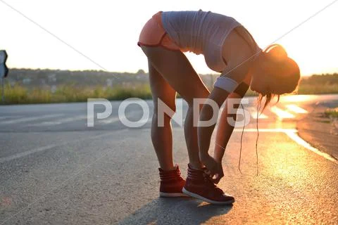 Young woman working out in the park at sunset or sunrise Stock Photos
