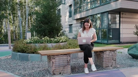 Young woman working on solving computer thinking problem outdoors Stock Footage 149426128