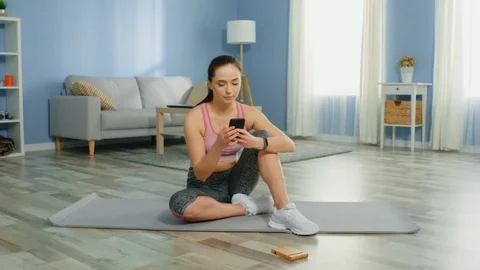 Young Woman Is Workouting Using Mobile Phone Application Stock Footage 129739773