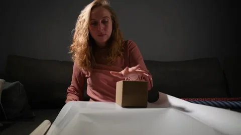 Young woman wrapping gift boxes in colorful paper Vídeos de archivo 340065531