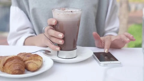 Young woman write message on smartphone while drinking cacao with croissant. Stock Footage 75068697