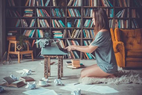 Young woman writer in library at home creative occupation typing concentrated Stock Photos
