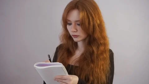 Young woman writes in a notebook, study, student, courses, long hair, girl Stock Footage 244308433