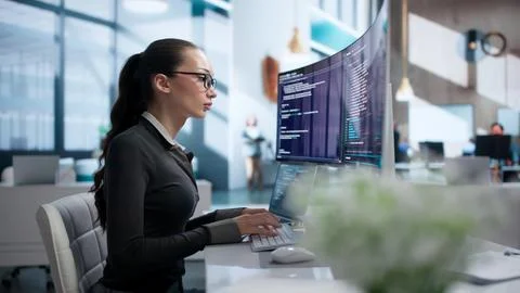 Young Woman Writes Software Code On Laptop Using Cloud-based Programming Tool Stock Photos