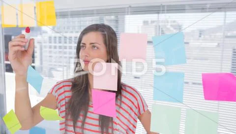 Young woman writing in creative office Stock Photos
