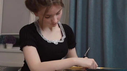 Young woman writing notes while studying at home Stock Footage 311807685