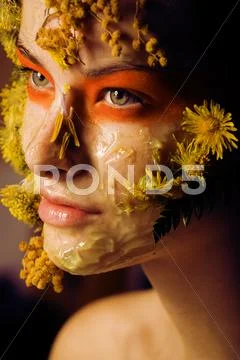 Young woman with yellow floral mask on her face close up, fashion makeup concept Stock Photos