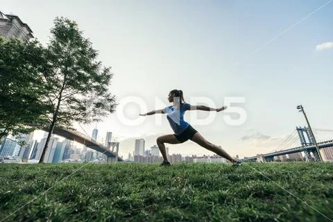 Young woman in yoga pose in park, New York, USA Stock Photos