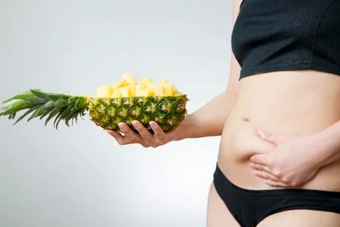 Young woman's body with pineapple Stock Photos