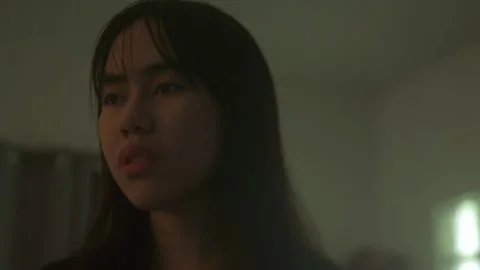 A Young Woman's Face Bears a Distant Expression, Reflecting Signs of Stock Footage 289100284