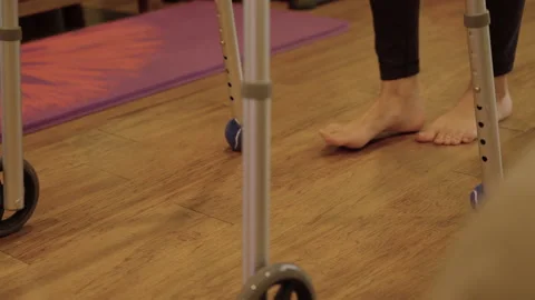 Young womans feet pushing walker through living room Stockbeeldmateriaal 284044752