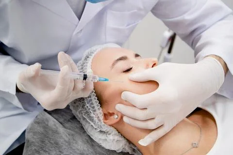 Young woman's getting injections to solve some age-related skin problems and 写真素材