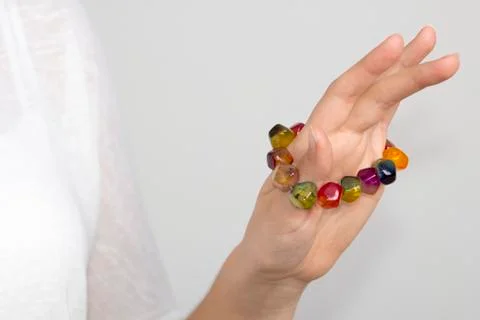 Young woman's hand with multi color bracelet Stock Photos