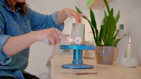 Young woman's hand in pottery studio using roller to shape mug on wheel 库存影片 221949643