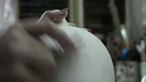 The young womans hand scrapes the surface of the jug. Close up. Grayscale Video stock 130526493