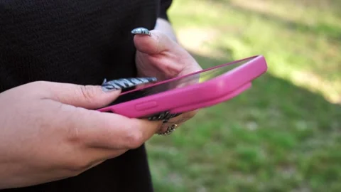 A young woman's hand using a mobile phone, texting, and browsing the internet Stock Footage 334723377