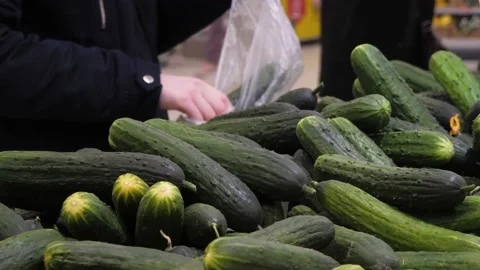 A young woman's hands are picking cucumbers at the supermarket. Stock Footage 232747394