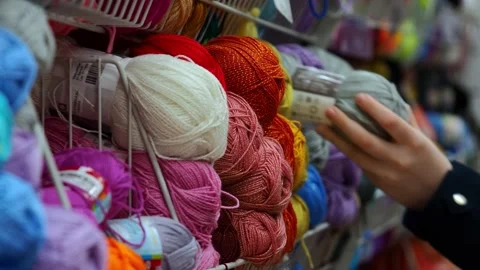 A young woman's hands choose the threads for knitting. Video stock 228999507