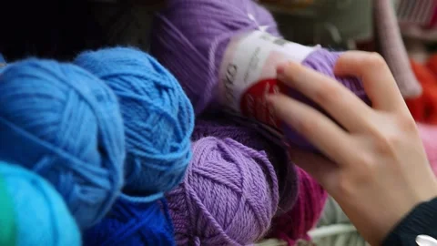 A young woman's hands choose the threads for knitting. Stock Footage 229295133