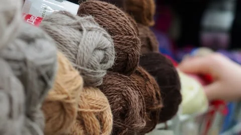A young woman's hands choose the threads for knitting. Video stock 229295335
