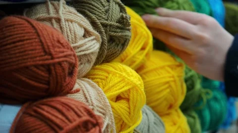 A young woman's hands choose the threads for knitting. Video stock 229295336