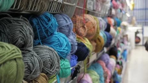 A young woman's hands choose the threads for knitting. Stock Footage 231092490